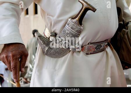 Omanische Mann mit einem khanjar oder Jambiya, der traditionellen Gravur silber Messer, Nizwa Souk, Oman Stockfoto