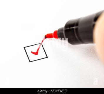 Person Setzen einer Markierung in einem Kontrollkästchen mit roter Markierung Stockfoto