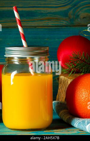 Glas Glas frisch gepressten Orangensaft mit frischen Früchten auf hölzernen Tisch Stockfoto