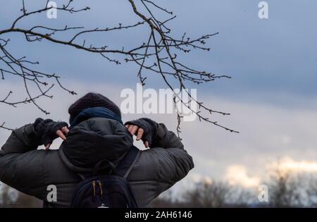 Muhr am See, Deutschland. 25 Dez, 2019. Eine Frau geht Spazieren und legt ihre Kapuze über den Kopf. Credit: Lino Mirgeler/dpa/Alamy leben Nachrichten Stockfoto