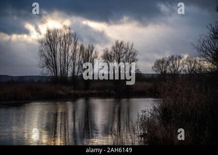 Muhr am See, Deutschland. 25 Dez, 2019. Bäume stehen vor dunklen Wolken am Altmühlsee. Credit: Lino Mirgeler/dpa/Alamy leben Nachrichten Stockfoto