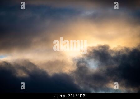 Muhr am See, Deutschland. 25 Dez, 2019. Dunkle Wolken mix bei Sonnenuntergang mit Wolken von Sonnenstrahlen beleuchtet. Credit: Lino Mirgeler/dpa/Alamy leben Nachrichten Stockfoto