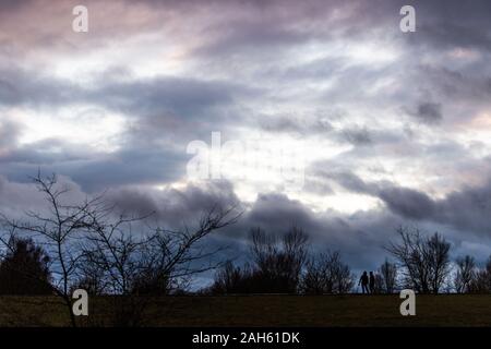 Muhr am See, Deutschland. 25 Dez, 2019. Wanderer zu Fuß entlang dem Deich an der Altmuehlee vor dunklen Wolken. Credit: Lino Mirgeler/dpa/Alamy leben Nachrichten Stockfoto