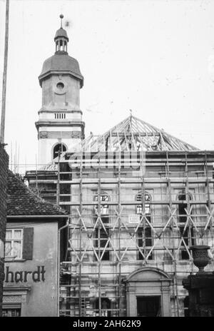 Blick vom Anwesen der ehemaligen Schmiede Wolf in der Würzburger Straße in Uffenheim/Mittelfranken in die wiederaufgebaute Stadtkirche St. Johannis, 1953. Die Kirche ist nahezu fertigestellt, es fehlt noch das Dach des Kirchengebäudes und die Turmuhr. Links das Haus der Gemischtwarenhandlung Gebhardt. Stockfoto