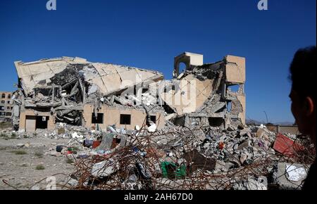 (191225) - DHAMAR (Jemen), Dez. 25, 2019 (Xinhua) - ein Junge schaut auf Gebäude in den Luftangriffen in Dhamar Provinz zerstört, Jemen, Dez. 25, 2019. Die andauernden Kämpfe zwischen den beiden verfeindeten Rivalen mit täglichen Saudi-geführten Luftangriffe Jemen in Chaos und Gewalt gestürzt. Drei Viertel der Bevölkerung, das sind mehr als 22 Millionen Menschen benötigen dringend irgendeine Form der humanitären Hilfe, einschließlich der 8,4 Millionen, die kämpfen, um ihre nächste Mahlzeit zu finden. (Foto von Mohammed Mohammed/Xinhua) Stockfoto