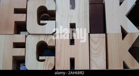 Holz- Buchstaben in dunklen Farben. Kann für die Dekoration und für pädagogische Zwecke genutzt werden. Das Foto wurde auf der Bank übernommen. Stockfoto