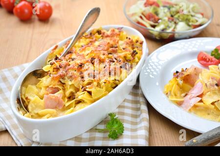 Gebackene österreichische Schinken Nudeln, so genannte schinkenfleckerl, und einem Beilagensalat mit Steirisches Kürbiskernöl Stockfoto