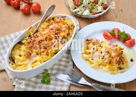 Gebackene österreichische Schinken Nudeln, so genannte schinkenfleckerl, und einem Beilagensalat mit Steirisches Kürbiskernöl Stockfoto