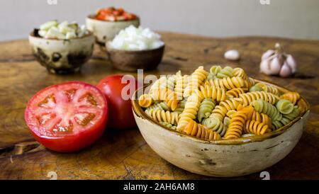 Frische Zutaten zum Kochen: Pasta, Tomaten, Paprika, Zwiebeln, Auberginen und Knoblauch über alten Holztisch Hintergrund. Stockfoto