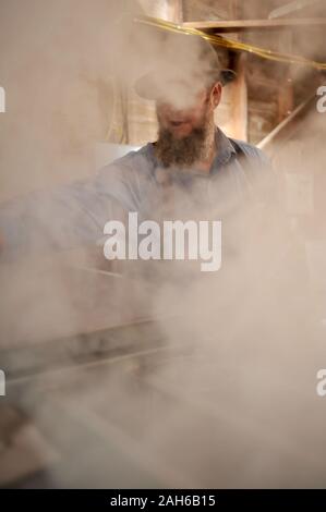 Die ahornsirup durch Tippen auf Ahornbäumen, Sammeln von Sap, Kochen mit Holz beheizte Verdampfer sap, dann Abfüllen in einem kleinen Sugar Shack, Wisconsin. Stockfoto