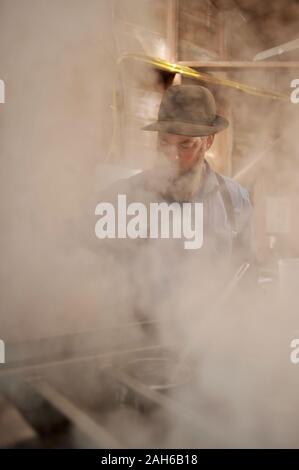 Die ahornsirup durch Tippen auf Ahornbäumen, Sammeln von Sap, Kochen mit Holz beheizte Verdampfer sap, dann Abfüllen in einem kleinen Sugar Shack, Wisconsin. Stockfoto