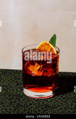 Negroni, ein italienischer Cocktail, ein Aperitif, der 1919 in Florenz, Italien, zum ersten Mal gemischt wurde. Garniert mit verkohltem Orange- und Salbeiblatt Stockfoto