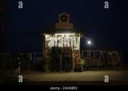 Gaza, Gaza, Palästina. 25 Dez, 2019. Eine palästinensische verkauft heisse Getränke am Strand von Gaza, den 25. Dezember 2019, und die Wellen sind hoch während der starke Wind schlagen der Strand in Gaza Stadt. Credit: Mahmoud Issa/Quds Net News/ZUMA Draht/Alamy leben Nachrichten Stockfoto