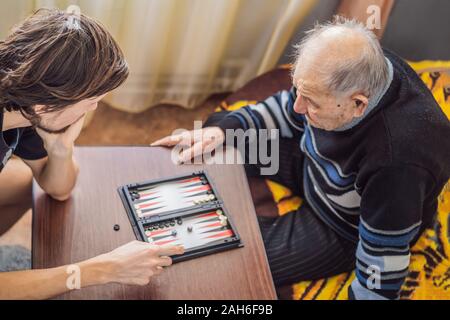 Ältere Menschen und sein Enkel spielen Sie Backgammon Stockfoto