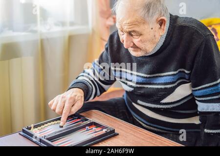 Älterer mann Backgammon in einem Pflegeheim spielen Stockfoto