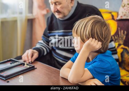 Ältere Menschen und sein Enkel spielen Sie Backgammon Stockfoto