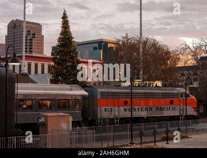 Sacramento, CA, May 12, 2019. Alte Southern Pacific Railroad Museum Dampflokomotive, der Altstadt von Sacramento Weihnachtsbaum und Sacramento Skyline im sunse Stockfoto