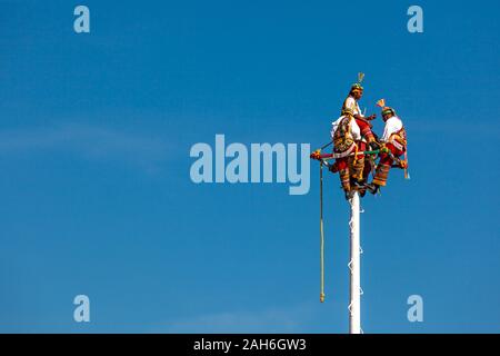 Teotihuacan, Mexiko - 25 November 2019: Drei Männer in Trachten sitzen auf einer Säule. Immer bereit für einen rituellen Tanz volador Stockfoto