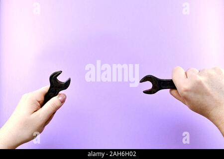 Zwei Schraubenschlüssel in Frauen Hände, eine auf der rechten Seite, der andere auf der linken Seite. Stockfoto