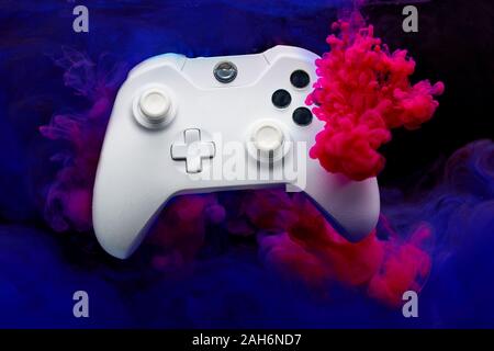 Spiel Joystick mit rosa und lila Rauch auf leeren schwarzen Hintergrund im Studio Stockfoto