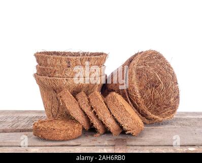 Kokos, Kokos, Blumentöpfe und wachsende Pellets, Scheiben gegen weißen Hintergrund. Umweltfreundliche Torf freie Feder Gartenarbeit. Stockfoto