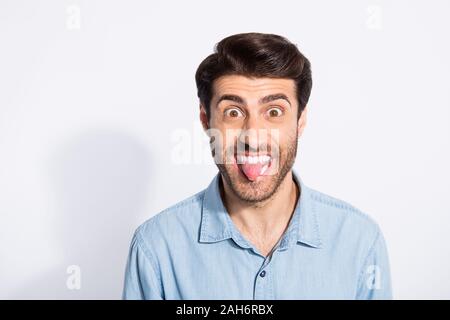 Foto von Multiethnischen unhöfliche Kerl haften Zunge aus dem Mund necken, Freundin Lachen tragen Casual denim Shirt isoliert weißer Farbe Hintergrund Stockfoto