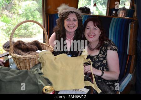 Zwei Damen, die eine 40er-Veranstaltung auf der Severn Valley Railway genießen. Wochenende in den vierziger Jahren, Shropshire, Großbritannien Stockfoto