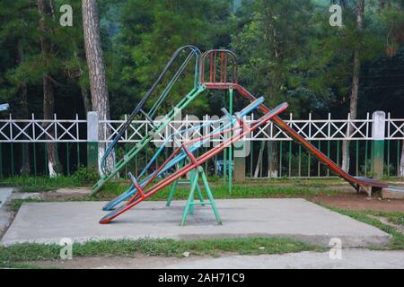 Nahaufnahme von einer Wippe aus Stahl Rohre und eine Rutsche im Hintergrund in einem Park im Elefanten fällt, Shillong, selektive Fokussierung Stockfoto