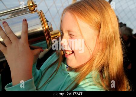 Mädchen aufgeregt mit Teleskop auf dem Eiffelturm, Paris Stockfoto