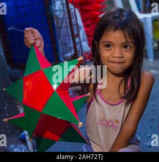 Philippinisches Mädchen mit einer Laterne auf einem Weihnachtsmarkt in Las Pinas Stadt, Manila auf den Philippinen Stockfoto