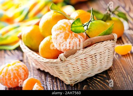 Mandarinen im Warenkorb und auf einem Tisch Stockfoto