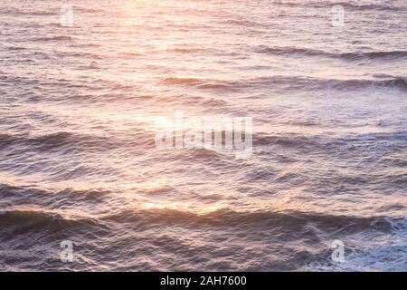 Luftaufnahme über den Ozean der aufgehenden Sonne über dem Wasser Wellen Oberfläche Stockfoto