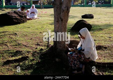 (191226) - Aceh, Dez. 26, 2019 (Xinhua) - Eine indonesische Frau betet Catalysts Lheue Masse Friedhof, wo der Tsunami 2004 tsunami Opfer während der Feierlichkeiten zum 15. Jahrestag der verheerenden Tsunami begraben sind, in Aceh, Indonesien, 26.12.2019. Mehr als 120.000 Menschen wurden in der Provinz Aceh durch ein fast 30 Meter hoher tsunami durch eine megathrust Erdbeben, die Unterwasserwelt vor der Küste von Sumatra Insel am Dez. 26, 2004 Struck ausgelöst getötet. Jedes Jahr, das Aceh Administration enthält eine Funktion zum Gedenken an das Erdbeben 2004 und Tsunami. Gehen mit'-Funktion: 15 Jahre auf, Indone Stockfoto