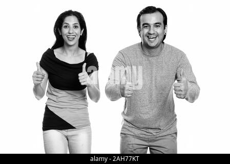 Studio shot von Happy persischen Paar lächelnd und geben Daumen bis zusammen Stockfoto
