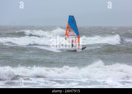 Bournemouth, Dorset UK. 26. Dezember 2019. UK Wetter: Wind surfer vor anspruchsvolle Bedingungen mit großen Wellen auf einem nassen Grau windigen Tag am Bournemouth. Credit: Carolyn Jenkins/Alamy leben Nachrichten Stockfoto