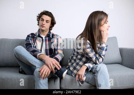 Junger Mann und Frau sitzt auf einem Sofa beleidigt. Stockfoto