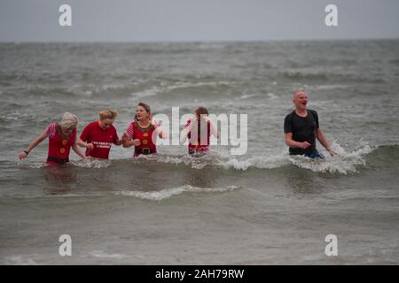 Tynemouth, England, 26. Dezember 2019. Die Teilnehmer in der Nordsee während der Boxing Day Dip, ist eine jährliche Veranstaltung, die von der Nordsee ehrenamtliche Rettungsschwimmer organisiert auf dem Longsands Tynemouth. Stockfoto