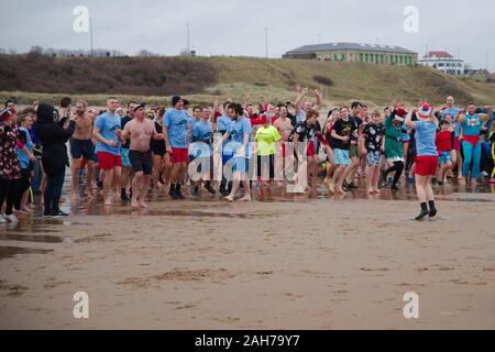 Tynemouth, England, 26. Dezember 2019. Teilnehmer aufwärmen, bevor Sie in die Nordsee während der Boxing Day Dip ist eine jährliche Veranstaltung, organisiert von der Nordsee Freiwillige Lifeguardson der Longsands Tynemouth. Stockfoto