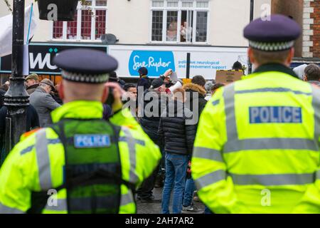 Tenterden, Kent,. 26 Dez, 2019. Die jährlichen Boxing Day treffen der Ashford Tal Tickham Jagd findet im Zentrum von Tenterden in Kent. Hunde und Pferde versammeln sich in der 'Vine Inn Pub bei 11, bevor Sie die High Street zu einem verpackten Publikum bin. Das Wetter ist nass und regnerisch Regen. Schwere Anwesenheit der Polizei bei der Jagd. Polizeibeamte mit Video und die Menge aufnehmen. © Paul Lawrenson 2019, Foto: Paul Lawrenson/Alamy leben Nachrichten Stockfoto