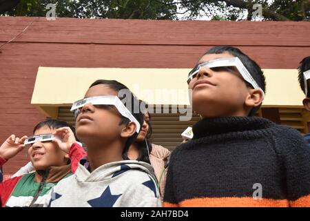 Kolkata, Indien. 26 Dez, 2019. Die ringförmige Sonnenfinsternis wird als partielle Sonnenfinsternis in Kalkutta von Schülern durch Solar anzeigen Filme beobachtet. (Foto durch Biswarup Ganguly/Pacific Press) Quelle: Pacific Press Agency/Alamy leben Nachrichten Stockfoto