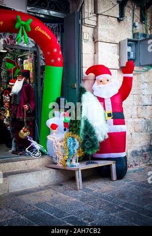 Zwei Santa Puppen groß die Passanten sowohl außerhalb als auch innerhalb einer Shop Eingang - Weihnachten Dekor Stockfoto