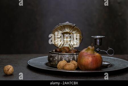 Birnen, Kastanien und Walnüsse auf einem Hintergrund von Silber vintage Zubehör Stockfoto