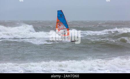 Bournemouth, Dorset UK. 26. Dezember 2019. UK Wetter: Wind surfer vor anspruchsvolle Bedingungen mit großen Wellen auf einem nassen Grau windigen Tag am Bournemouth. Credit: Carolyn Jenkins/Alamy leben Nachrichten Stockfoto