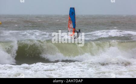 Bournemouth, Dorset UK. 26. Dezember 2019. UK Wetter: Wind surfer vor anspruchsvolle Bedingungen mit großen Wellen auf einem nassen Grau windigen Tag am Bournemouth. Credit: Carolyn Jenkins/Alamy leben Nachrichten Stockfoto