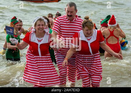 Jubiläum Strand, Southend-on-Sea, Großbritannien. 26 Dez, 2019. Pat Lamm (links), 83, Bürgermeisterin von Southend. Über 200 Teilnehmer trotzen dem kaltes Wasser in Southend-on-Sea, einige in Fancy Dress, nehmen teil an der Southend RNLI Boxing Day Dip. Der Sieger, die Person, die in der Kälte 5-6 C Wasser an der Mündung der Themse, dem längsten bleiben können. Penelope Barritt/Alamy leben Nachrichten Stockfoto