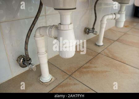 In der Nähe von weißen Kunststoff Rohr entleeren Unter waschen Waschbecken im Badezimmer. Stockfoto