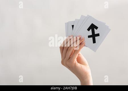 7/8-Ansicht von Frau mit Karten mit Sternzeichen isoliert auf Grau Stockfoto