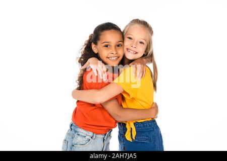 Zwei glückliche multikulturellen Freunde umarmen, während bei Camera isoliert auf weißem suchen Stockfoto