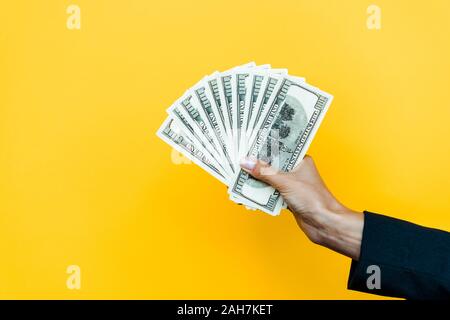 7/8-Ansicht von Frau mit Dollar Banknoten auf Orange Stockfoto