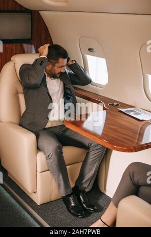 7/8-Ansicht von Geschäftsfrau, Sitzen mit bärtigen Geschäftsmann in der Ebene Stockfoto